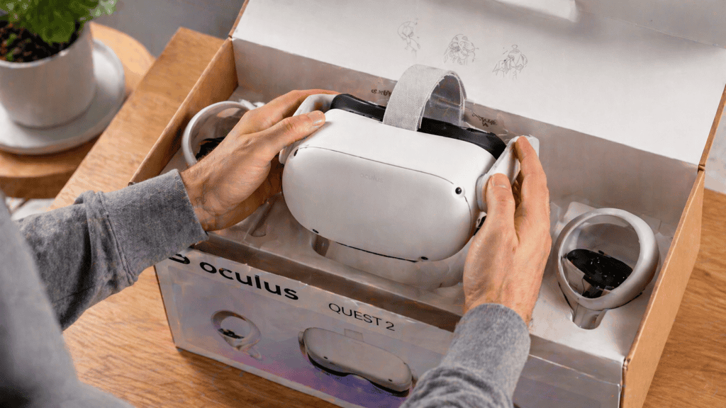 A close-up view of a user carefully removing the Oculus Quest 2 headset from the box, showing hands handling the device gently. Crisp lighting, clean and modern background, realistic hand details, hd quality, slight angle from above, focused on the action